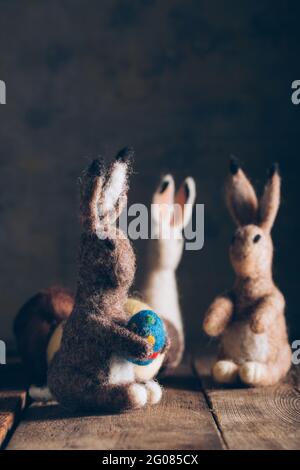 Hand made easter rabbit made of wool and felt on dark wooden table Stock Photo