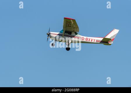 Cessna 152 light aircraft plane G-BXVY flying in blue sky at Stapleford Aerodrome, Essex, UK. Flying training, in old aircraft first flown in 1979 Stock Photo