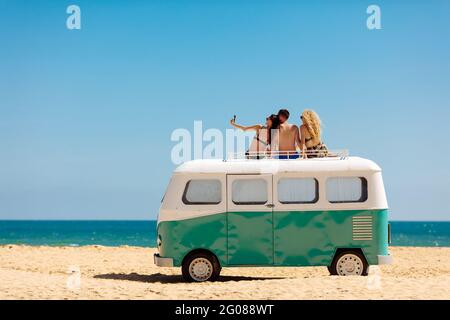 Three friends in summer clothing taking selfie on phone Stock Photo