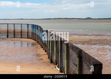 A netted safe swimming enclosure on a beach with the tide out Stock Photo