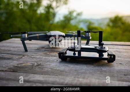 DJI Mavic pro drone with a mobile phone plugged to a controller on a wooden table Stock Photo