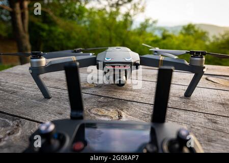 DJI Mavic Pro drone and its controller with antennas on a wooden table outdoors Stock Photo