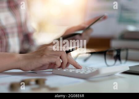 Close up woman calculating monthly home expenses, taxes, bank account balance and credit card bills payment, Income is not enough for expenses Stock Photo