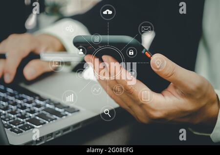 Businessman working with smart phone and laptop  computer with digital marketing graph business finance technology concept media in virtual icon at of Stock Photo