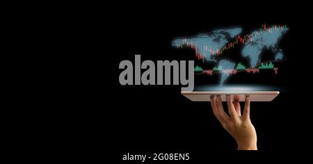 Stock market trading concept with a digital tablet businessmen holding hand on virtual screen. Business finance and graph with world map on dark backg Stock Photo