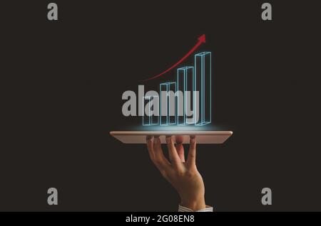 businessmen hand holding  tablet graph digital Financial investment and  arrow red  on virtual screen. Business technology concept Stock Photo