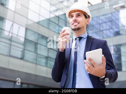 Male in jacket and helmet working at tablet Stock Photo