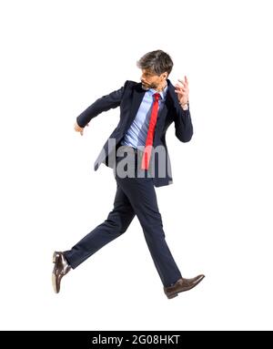 Jubilant successful stylish businessman walking on air looking back over his shoulder in a conceptual image of the idiom isolated over a white studio Stock Photo
