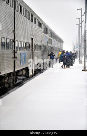 Geneva, Illinois, USA. Passengers departing a Metra commuter train during a snowstorm in suburban Chicago. Stock Photo