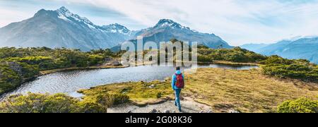 New Zealand Hiking. Young hiking man walking on trail at Routeburn Track during sunny day. Hiker tramping Key Summit Track in Fiordland National Park Stock Photo
