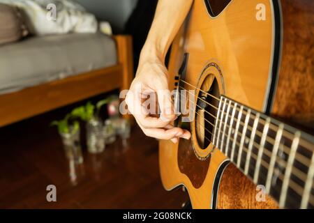 Playing acoustic guitar in bedroom Stock Photo