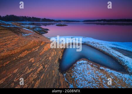 Beautiful rock formations and colorful winter evening skies at Oven by the Oslofjord, Råde kommune, Østfold, Norway, Scandinavia. Stock Photo