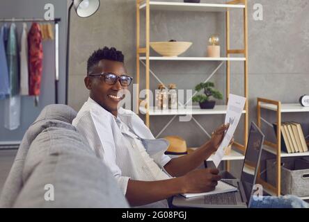 Happy successful black businessman working on couch in his comfortable home office Stock Photo