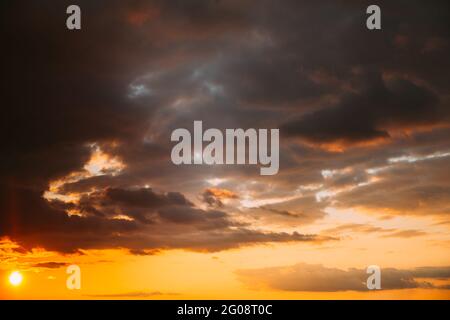 Sunset Cloudy Sky With Fluffy Clouds. Sunset Sky Natural Background. Sunrays, sunray, ray, Dramatic Sky. Sunset In Yellow, Orange, Pink Colors Stock Photo