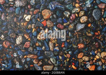 Dark texture of asphalt mixed with many small multi-colored stones Stock Photo