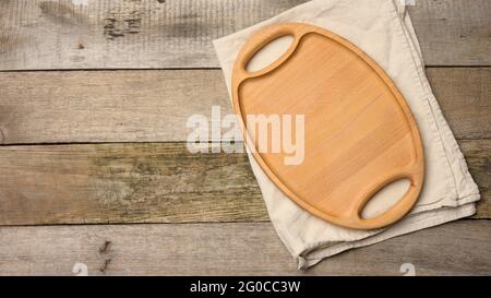 empty oval brown wooden tray board on a wooden background, top view Stock Photo