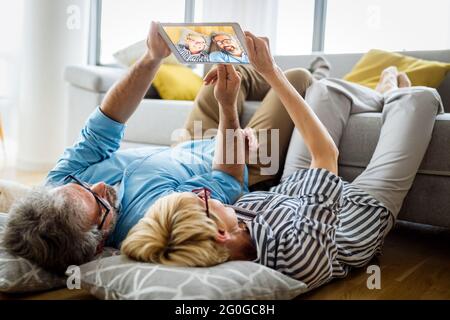 Happy smiling mature couple using digital tablet at home Stock Photo