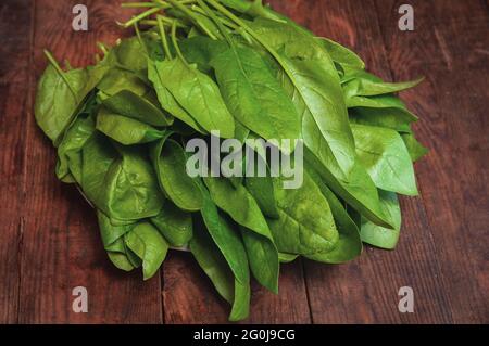 fresh spinach lies  on a wooden table Stock Photo