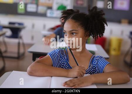 African american girl studying while sitting on her desk in the class at school Stock Photo