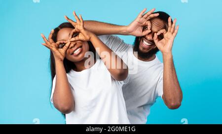 Black couple smiling, looking at the camera through fingers Stock Photo