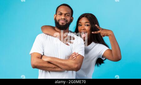 Black couple posing showing victory sign or peace gesture Stock Photo