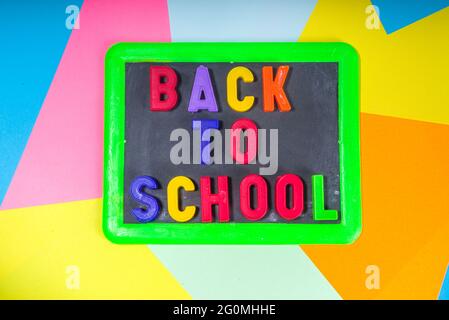 Back To School Concept. Various school stationery and supplies - chalk, color pencil, paints, notebooks, brushes, tablet, small blackboard. Flatlay to Stock Photo