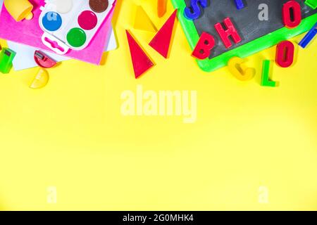 Back To School Concept. Various school stationery and supplies - chalk, color pencil, paints, notebooks, brushes, tablet, small blackboard. Flatlay to Stock Photo