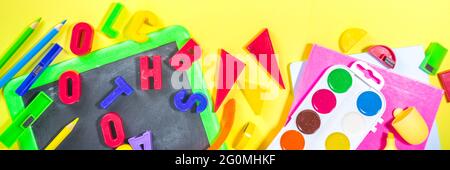 Back To School Concept. Various school stationery and supplies - chalk, color pencil, paints, notebooks, brushes, tablet, small blackboard. Flatlay to Stock Photo