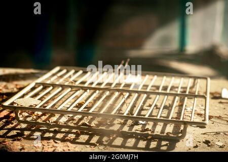 An old white refrigerator shelf in an abandoned and devastated kitchen Stock Photo