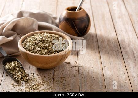 Traditional yerba mate tea in bowl on wooden table Stock Photo