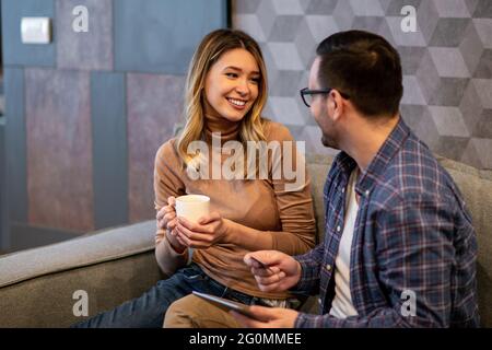 Young couple at home. Handsome man and attractive woman are spending time together.Excited young couple shopping online. Stock Photo