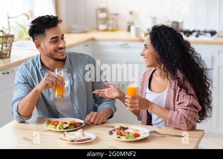 Cheerful young arab couple having breakfast together at home Stock Photo