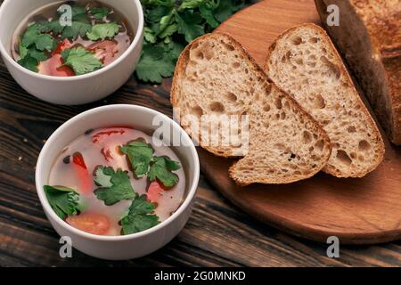 slices of bread and two plates of soup on the kitchen table. Stock Photo