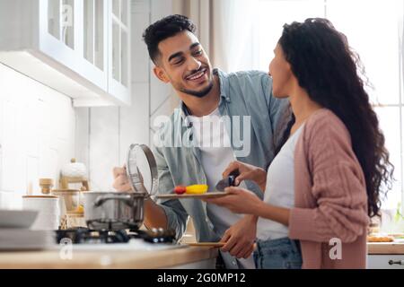 Happy Middle Eastern Spouses Preparing Lunch Together In Kitchen Stock Photo