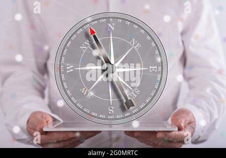Right direction concept above a tablet held by a man in background Stock Photo