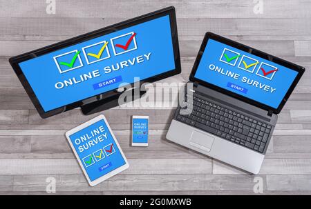 Online survey concept shown on different information technology devices Stock Photo