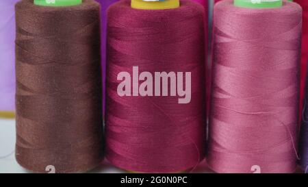 Shooting of colored bobbins of threads in workshop Stock Photo