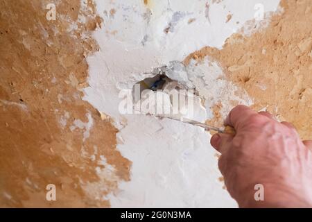Repairing the wall - Man putting spackle on a hole in the wall Stock Photo
