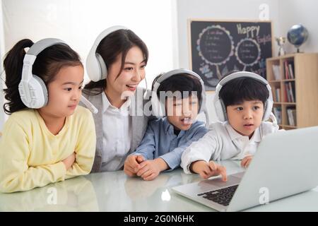 The teacher counseling the children use the computer Stock Photo