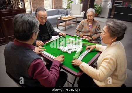 Happy old people playing mahjong Stock Photo