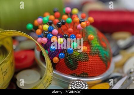Pin cushion with lots of colorful pins in a close-up Stock Photo