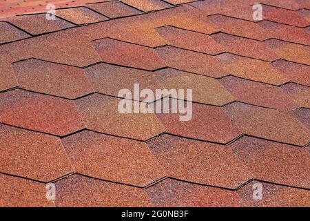 roof texture of building covered with soft bitumen shingles stone dusting tiles for water resistance protective coating closeup view, nobody. Stock Photo