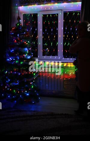 Christmas elegant tree stands under the window Stock Photo