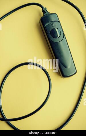 A remote shutter release for a digital camera isolated on a yellow background Stock Photo