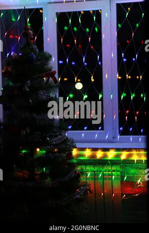 Christmas elegant tree stands under the window Stock Photo