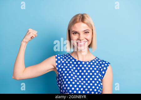 Photo of young attractive girl happy positive smile show hands biceps sportive hero isolated over blue color background Stock Photo