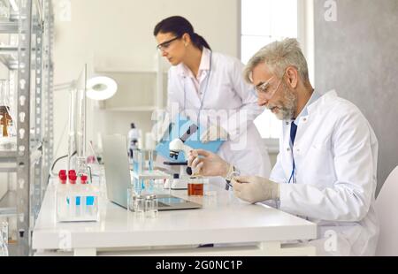 Medical scientists working in laboratory, doing research and using modern lab equipment Stock Photo