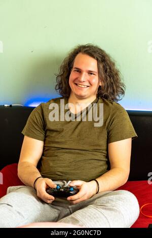 Cheerful guy is playing a video game using a joystick Stock Photo