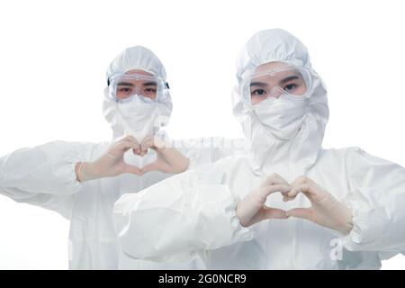 Medical staff wearing protective clothing do love gestures Stock Photo
