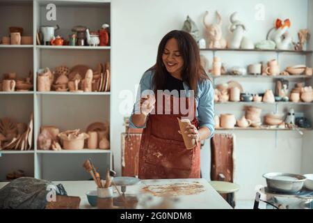 Charming young woman working in pottery workshop Stock Photo